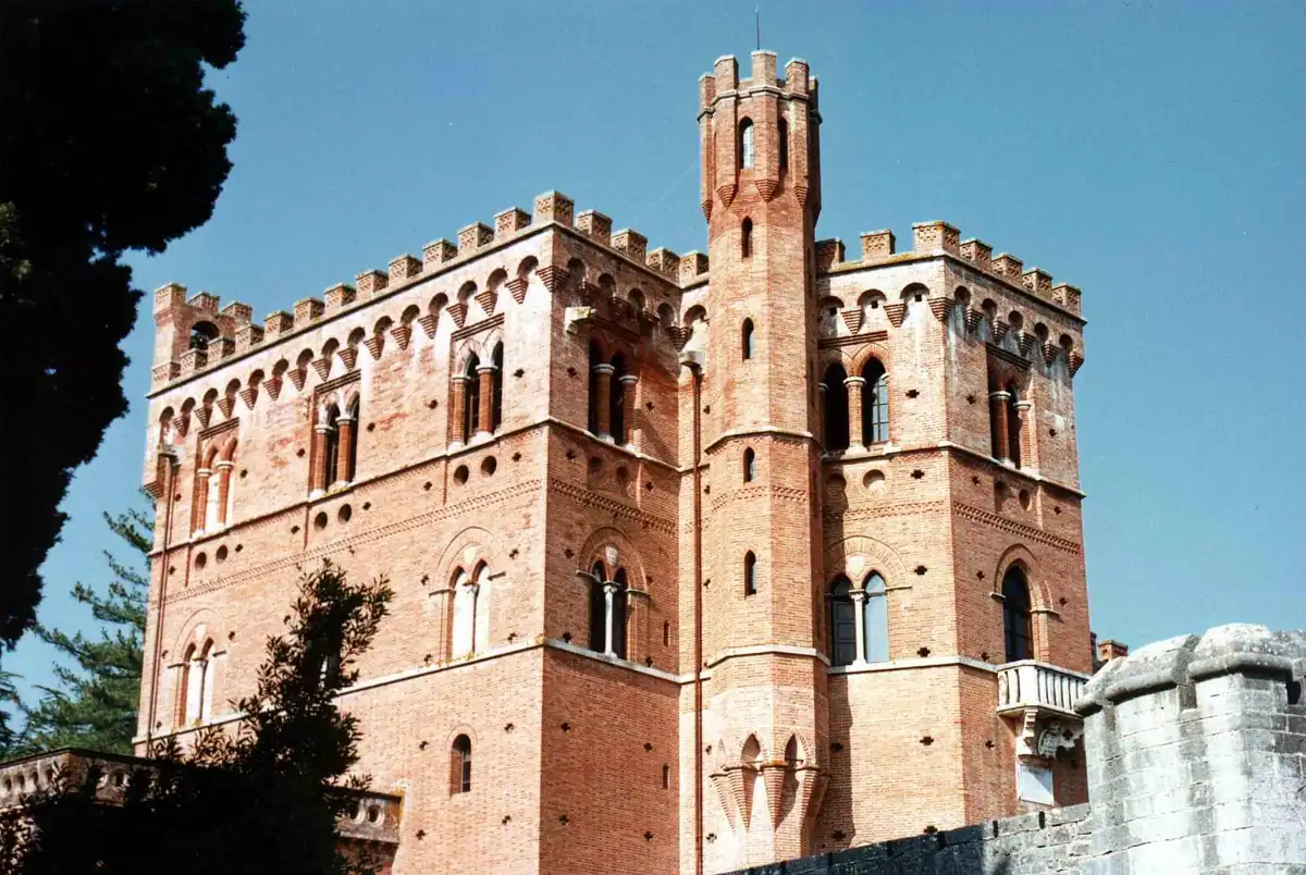 Veduta ravvicinata del Castello di Brolio a Gaiole in Chianti, con mura merlate e torre in mattoni.