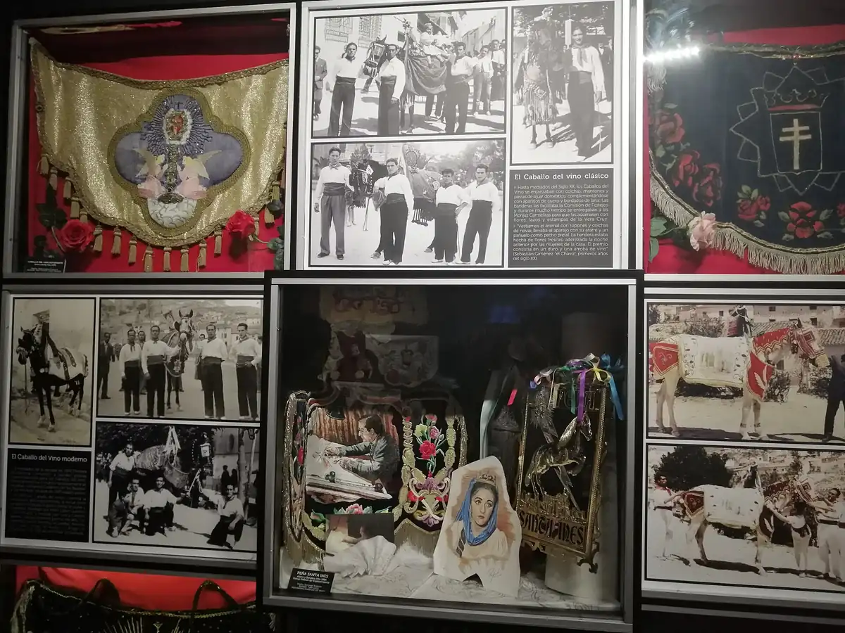 Vetrina museale con foto storiche e drappi decorati dedicati al vino