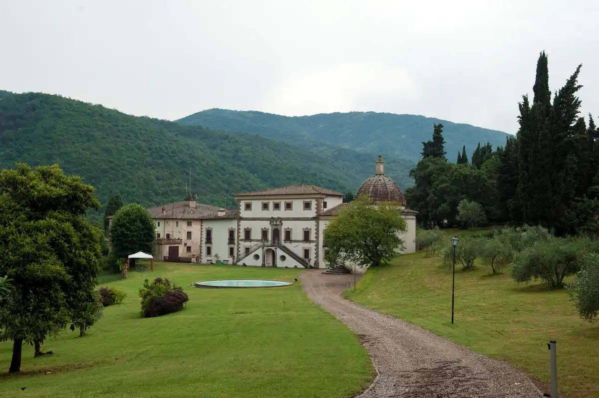 Villa di Cintoia immersa nel verde, con giardino, cipressi e montagne sullo sfondo
