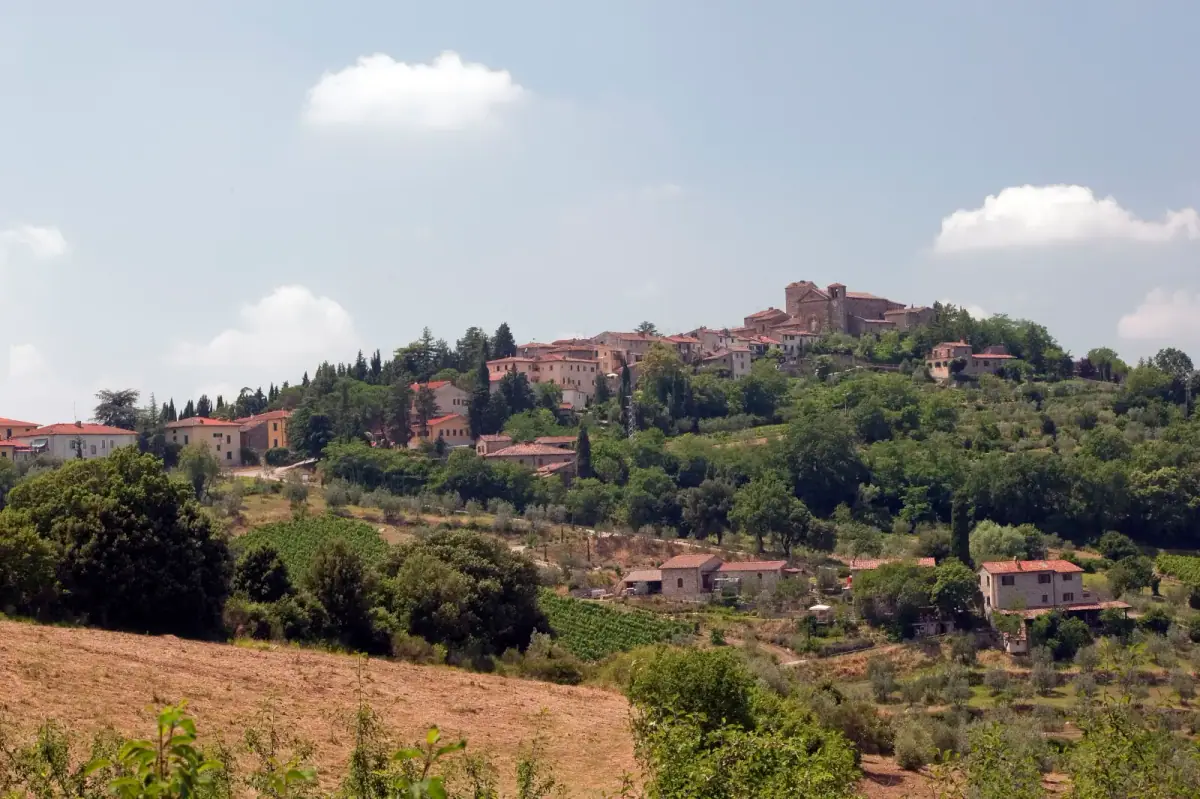 Panzano in Chianti su un crinale, con la chiesa del borgo tra case e colline verdi