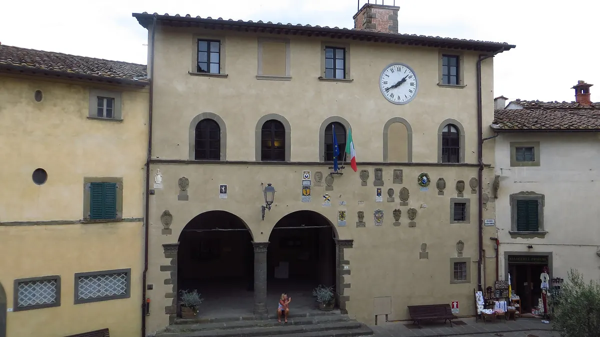 Facciata del palazzo comunale di Radda con loggiato, orologio e bandiere