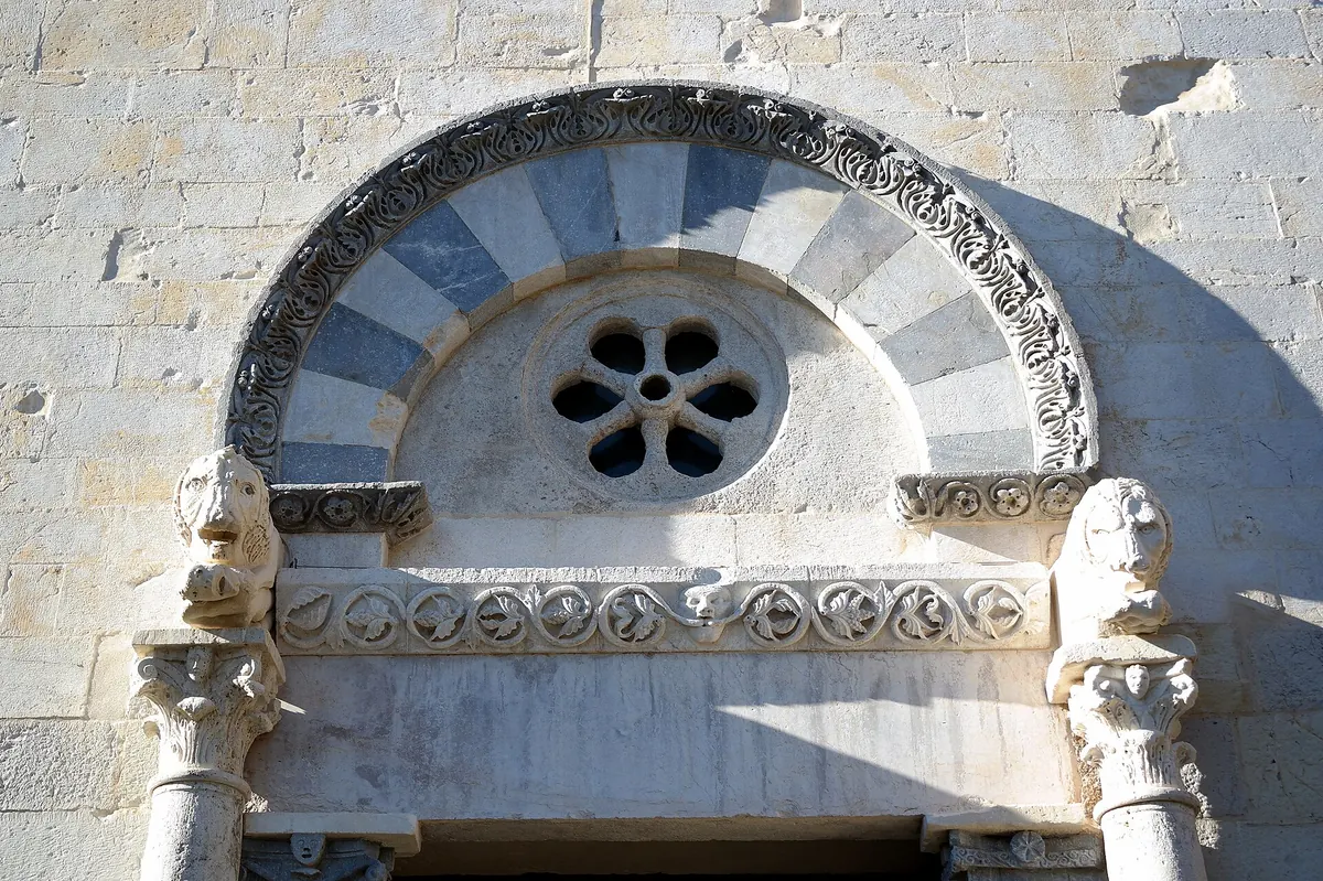 Dettaglio della facciata della pieve di San Giusto con arco decorato e piccola rosone