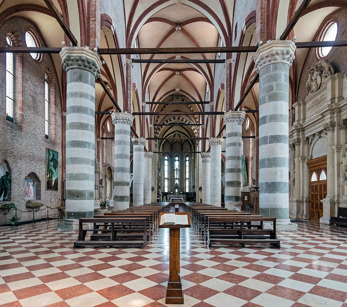 Navata centrale dell'interno della Chiesa di San Lorenzo con colonne, banchi e altare